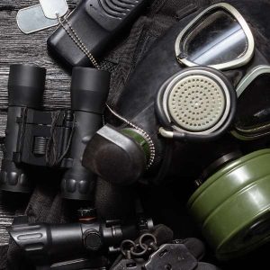 Imagen que muestra muchos accesorios para usar en batallas de gelsoft. Podemos ver mascaras, gafas protectoras, prismáticos y chapas de guerra.